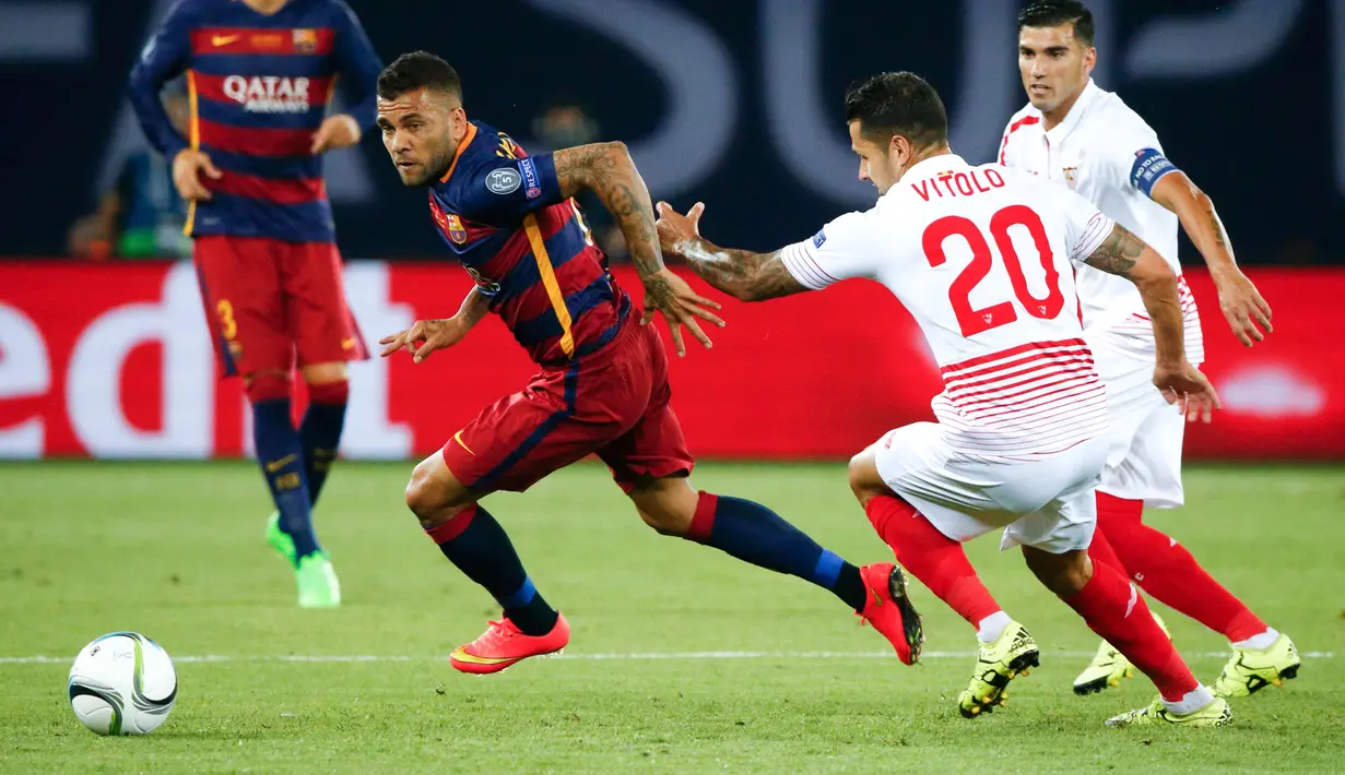 Bek Barcelona, Daniel Alves (kiri) berusaha melewati gelandang Sevilla, Vitolo pada pertandingan Piala Super Eropa 2015 di Stadion Boris Paichadze, Tbilisi, Georgia, (12/8/2015). Barcelona menang atas Sevilla dengan skor 5-4. (REUTERS/Grigory Dukor)
