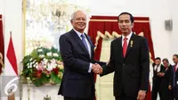 PM Malaysia, HE Dato Sri Muhammad Najib Tun Abdul Razak (kiri) bersalaman dengan Presiden Jokowi (kanan) saat tiba di Jakarta, Senin (1/8). Pertemuan membahas Konsultasi Bilateral Tahunan RI-Malaysia ke-11. (Liputan6.com/Faizal Fanani)
