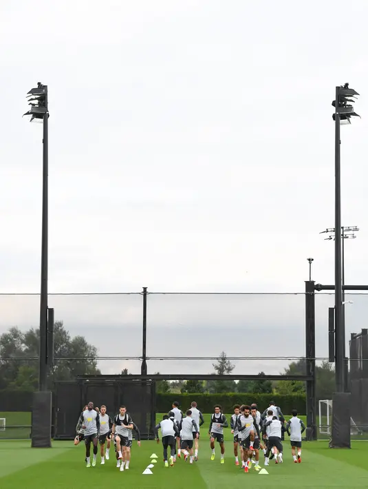 Para pemain Liverpool melakukan pemanasan saat menghadiri sesi latihan di pusat pelatihan Axa di Kirkby, Liverpool, Inggris (14/9/2021). Liverpool akan bertanding melawan wakil Italia, AC Milan pada Grup B Liga Champions di Anfield. (AFP/Paul Ellis)