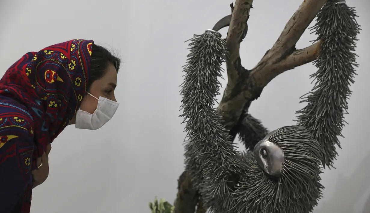 Seorang wanita melihat patung hewan yang terbuat dari logam tipis di area indoor Shahreza Metal Zoo di pusat kota Shahreza sekitar 425 kilometer selatan ibu kota Teheran, Iran pada 13 Oktober 2021. Seniman bersuadara itu membuat 30 patung binatang dalam jangka waktu 15 bulan. (AP Photo/Vahid Salemi)