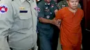 Yem Chrin (kanan) saat memasuki  ruangan sidang di Pengadilan Provinsi Battambang,Kamboja,Kamis (3/12). Diduga dalam prakteknya Yem Chrin menggunakan obat tak berlisensi, suntik bekas dan melakukan malpraktek. (REUTERS/Stringer)