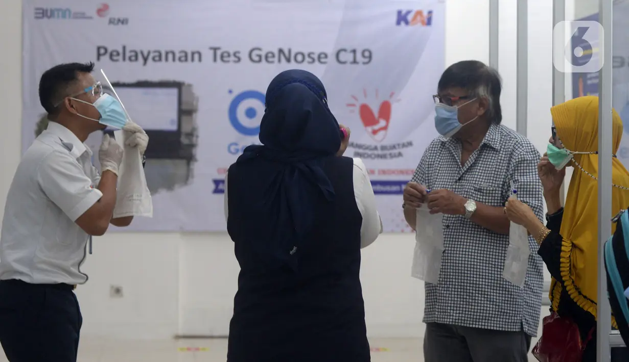 Petugas mengajari calon penumpang untuk tes COVID-19 dengan GeNose C19 di Stasiun Pasar Senen, Jakarta, Selasa (23/2/2021). Hasil tes tersebut kemudian menjadi dokumen syarat perjalanan para penumpang kereta. (merdeka.com/Imam Buhori)