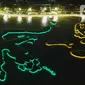 Foto udara memperlihatkan warna warni lampu Danau Archipelago di Taman Mini Indonesia Indah (TMII), Jakarta, Sabtu (31/12/2022). Pemerintah Provinsi DKI Jakarta akan memusatkan perayaan malam Tahun Baru 2023 di Taman Mini Indonesia Indah (TMII).  (Liputan6.com/Herman Zakharia)