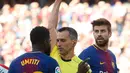 Wasit memberikan kartu kuning kepada bek Prancis Barcelona Samuel Umtiti saat melawan Athletic Bilbao dalam pertandingan La Liga Spanyol di stadion Camp Nou di Barcelona (18/3). (AFP Photo/Pau Barrena)