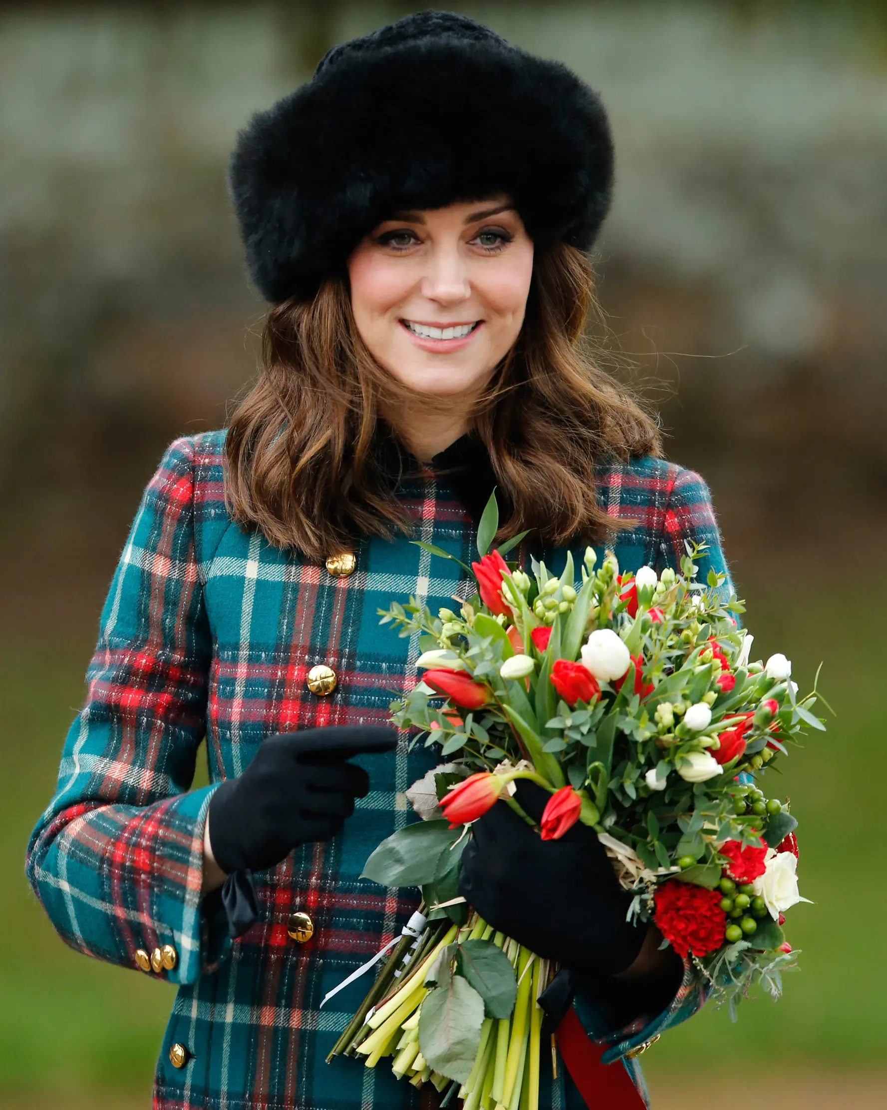 Kate Middleton menggenggam buket bunga usai tradisi kebaktian Hari Natal Kerajaan Inggris di Gereja St. Mary Magdalene, Sandringham, Senin (25/12). Kate membiarkan rambut coklatnya tergerai dan riasan wajah natural dengan lipstik nude. (AP/Alastair Grant)