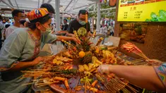 Para pengunjung memilih kudapan pedas di jalan camilan Grand Bazaar di Urumqi, ibu kota Daerah Otonom Uighur Xinjiang, China barat laut, pada 4 Juli 2020. (Xinhua/Zhao Ge)
