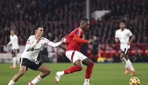 Bek kanan Liverpool, Trent Alexander-Arnold, bertarung memperebutkan bola dengan pemain Nottingham Forest, Callum Hudson-Odoi, dalam laga pekan 21 Premier League di City Ground Stadium, Rabu (15/1/2025) dini hari WIB. Liverpool dan Nottingham Forest bermain imbang 1-1. (AP Photo/Darren Staples)