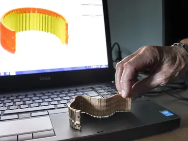 Seorang pekerja Comite Franceclat memperlihatkan gelang emas hasil mesin cetak 3D di Besancon, Prancis, 11 Oktober 2017. Mesin cetak 3D kini mulai merambah ke dunia desain perhiasan. (AFP FOTO / SEBASTIEN BOZON)