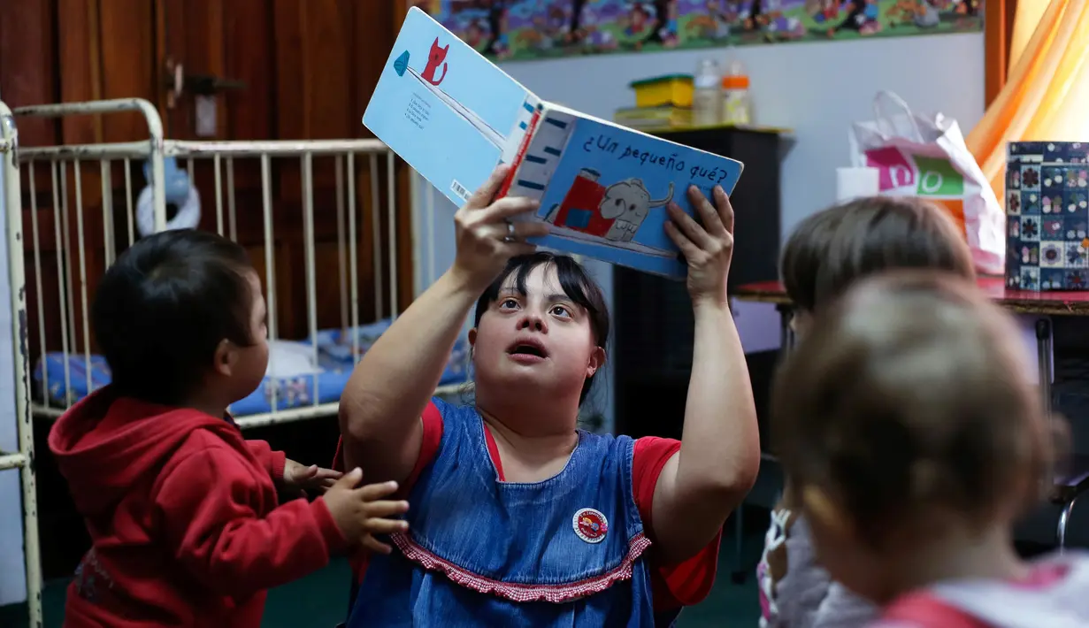 Seorang guru TK, Noelia Garella membacakan buku ke anak-anak saat bertugas di TK Jeromito, Cordoba, Argentina (24/10). Noelia 31 tahun merupakan penderita down syndrome pertama yang menjadi guru TK. (AFP Photo/Diego Lima)