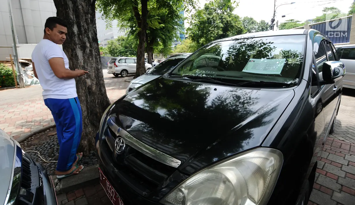 Warga melihat-lihat mobil operasional KPK yang akan dilelang di Gedung KPK Lama, Jakarta, Selasa (27/2). KPK bakal menggelar lelang barang inventaris pada Kamis (1/3/2018) mulai pukul 10.00 WIB sampai dengan selesai. (Liputan6.com/Helmi Fithriansyah)