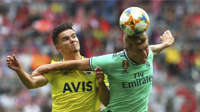 Gelandang Real Madrid, Toni Kroos berebut bola udara dengan pemain Fenerbahce, Ferdi Kadioglu selama pertandingan Audi Cup 2019 di stadion Allianz Arena di Munich, Jerman (31/7/2019). Madrid menempati posisi ketiga di Audi Cup 2019. (AP Photo/Matthias Schrader)