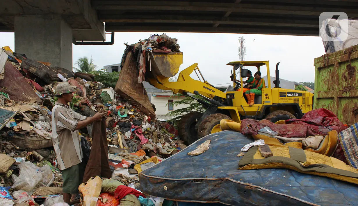 Petugas PPSU DKI Jakarta menggunakan alat berat mengangkut sampah di bawah Tol Becakayu, Cipinang Melayu, Jakarta Timur, Rabu (8/1/2020). Sampah sisa banjir tersebut selanjutnya diangkut ke TPA Bantar Gebang. (merdeka.com/Magang/Muhammad Fayyadh)