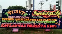 Guna menyadarkan masyarakat, polisi menyebar papan karangan bunga di setiap perempatan lampu merah di Kota Pekanbaru. (Liputan6.com/M Syukur)