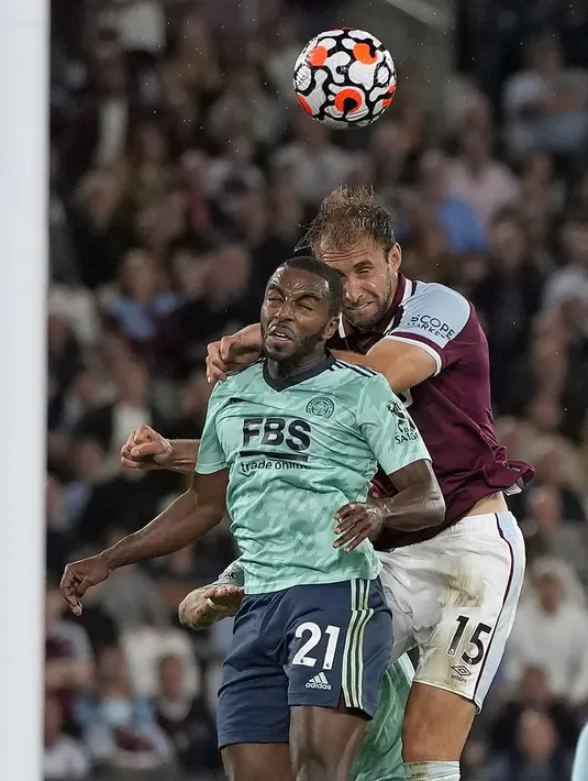 Pemain West Ham United Craig Dawson (kanan) melewati pemain Leicester City Ricardo Pereira untuk menyundul bola pada pertandingan Liga Inggris di London Stadium, London, Inggris, Senin (23/8/2021). West Ham United menang 4-1. (AP Photo/Alastair Grant)