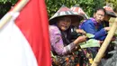 Sejumlah petani Kendeng menyantap makanan saat aksi di depan Istana Negara, Jakarta, Kamis (2/8). Dalam aksinya, mereka melakukan tradisi Brokohan memperingati pertemuan mereka dengan Presiden Jokowi. (Liputan6.com/Helmi Fithriansyah)