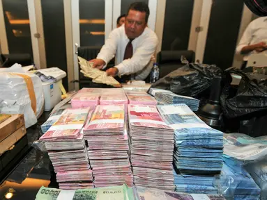 Bareskrim Polri merilis uang palsu yang didapat dari berbagai daerah sepanjang November 2015, Jakarta, Senin (7/12/2015). Ratusan lembar uang palsu tersebut diduga akan disebar dalam pilkada serentak (Liputan6.com/Yoppy Renato)