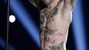Vokalis Maroon 5 Adam Levine membuka bajunya saat tampil memeriahkan pertandingan antara Los Angeles Rams dan New England Patriots dalam Super Bowl LIII di Atlanta, Georgia, AS, Minggu (3/2). (AP Photo/Mark Humphrey)
