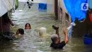 Aktivitas warga di tengah banjir yang merendam kawasan Kampung Melayu Kecil, Bukit Duri, Jakarta, Selasa (25/2/2020). Banjir tersebut akibat luapan sungai Ciliwung. (merdeka.com/magang/ Muhammad Fayyadh)
