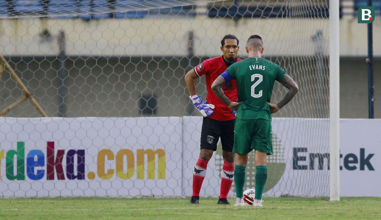 Kiper Persela Lamongan, Dwi Kuswanto menatap pemain PSS Sleman, Aaron Evans yang akan menendang penalti dalam laga matchday ke-2 Grup C Piala Menpora 2021 di Stadion Si Jalak Harupat, Bandung, Minggu (28/3/2021). PSS Sleman bermain imbang 0-0 dengan Persela Lamongan. (Bola.com/M Iqbal Ichsan)
