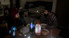 Zulfaqaar Seedat (kanan) dan Kurshaid Shaik (kiri) mengonsumsi makanan pada saat sahur, yaitu makanan yang dikonsumsi di pagi hari oleh umat Islam selama bulan Ramadhan sebelum berpuasa, menjelang matahari terbit) pada 12 April 2023 di Robertsham, Johannesburg saat terjadi pemadaman listrik bergilir. (Photo by Shiraaz Mohamed / AFP)