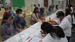 Puluhan pasangan yang mengenakan masker untuk melindungi diri dari penyebaran virus corona menunggu untuk menandatangani surat nikah mereka pada Hari Valentine di distrik Bang-Rak, yang diterjemahkan sebagai "Distrik Cinta", di Bangkok, Thailand, Senin (14/2/2022). (AP Photo/Sakchai Lalit)
