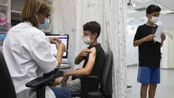 Seorang remaja Israel menerima vaksin COVID-19 Pfizer-BioNTech di kota Rishon LeZion, Minggu (6/6/2021). Israel mulai memvaksinasi anak-anak dari usia 12 hingga 15 pada hari Minggu. (AP Photo/Sebastian Scheiner)
