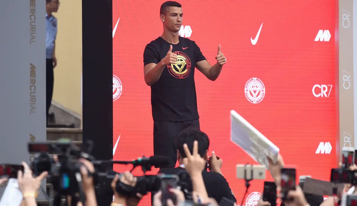 Pemain timnas Portugal, Cristiano Ronaldo mengacungkan jempolnya ketika menyapa penggemar saat rangkaian “CR7 Tour” yang disponsori Nike di Beijing, Kamis (19/7). Pemain berjuluk CR7 itu terbang ke China dengan menaiki jet pribadi. (WANG ZHAO/AFP)