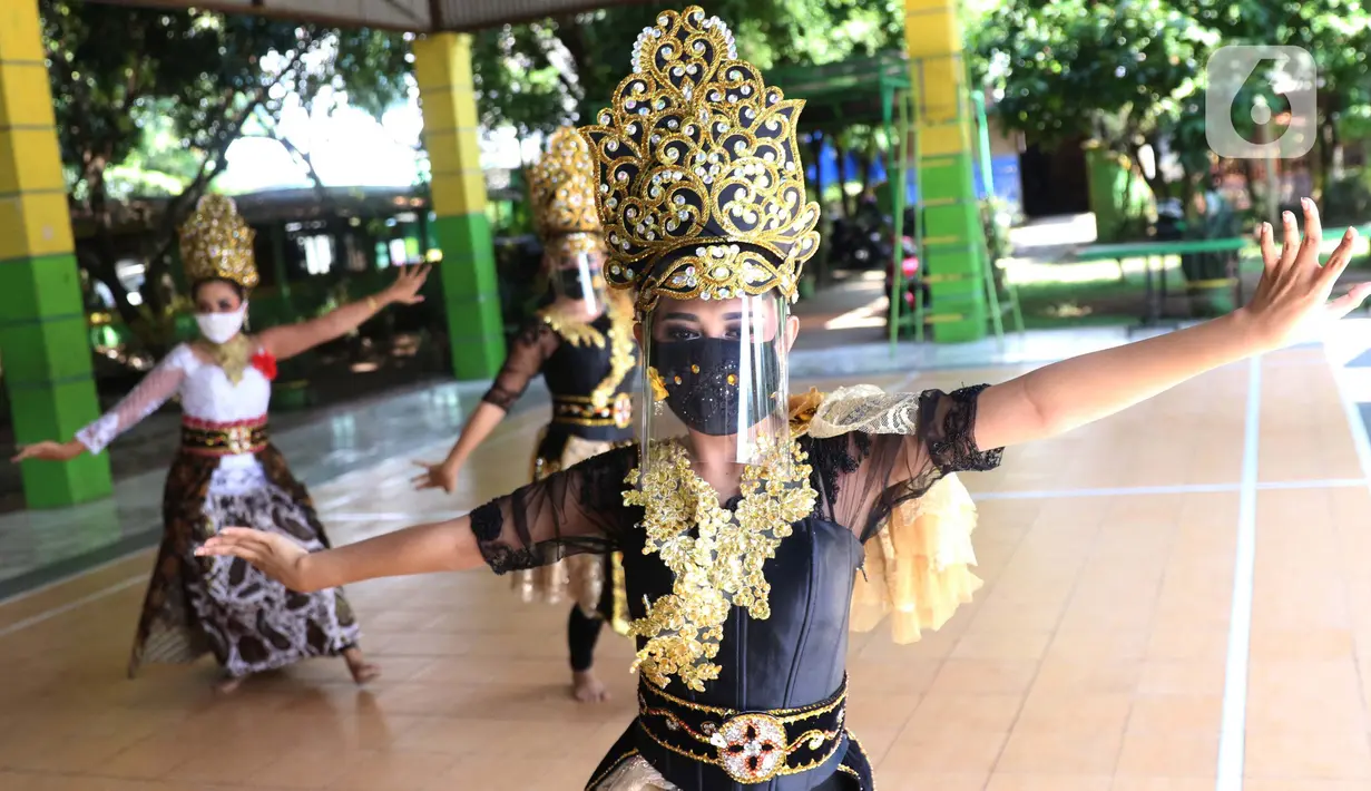Sejumlah penari tradisional sanggar seni Eschoda mengenakan masker dan pelindung wajah saat latihan di Kota Tangerang, Banten, Jumat (12/6/2020). Para penari menerapkan protokol kesehatan jelang penerapan kenormalan baru menghadapi virus corona COVID-19. (Liputan6.com/Angga Yuniar)