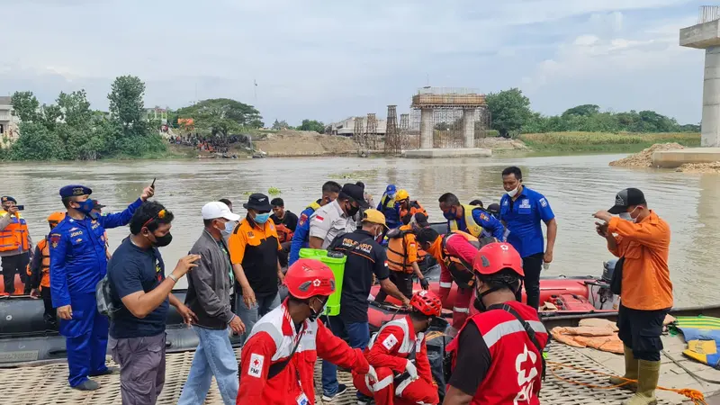 Petugas mengevakuasi korban perahu tenggelam di Bengawan Solo. (Ahmad Adirin/Liputan6.com)