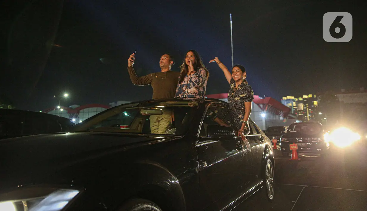 Penonton menikmati konser New Live Experience 2020 pada hari kedua di Parkir Barat JIExpo Kemayoran, Jakarta, Minggu (30/8/2020). Konser musik dengan konsep drive-in tersebut digelar dengan menerapkan protokol kesehatan untuk mencegah penyebaran COVID-19. (Liputan6.com/Faizal Fanani)
