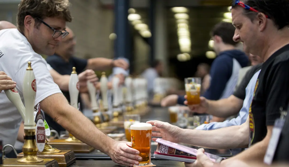 Staf bar melayani penggemar bir selama The Great British Beer Festival di Kensington Olympia di London barat (6/8/2019). Great British Beer Festival tahunan ini diadakan 6-10 Agustus 2019. (AFP Photo/Tolga Akmen)