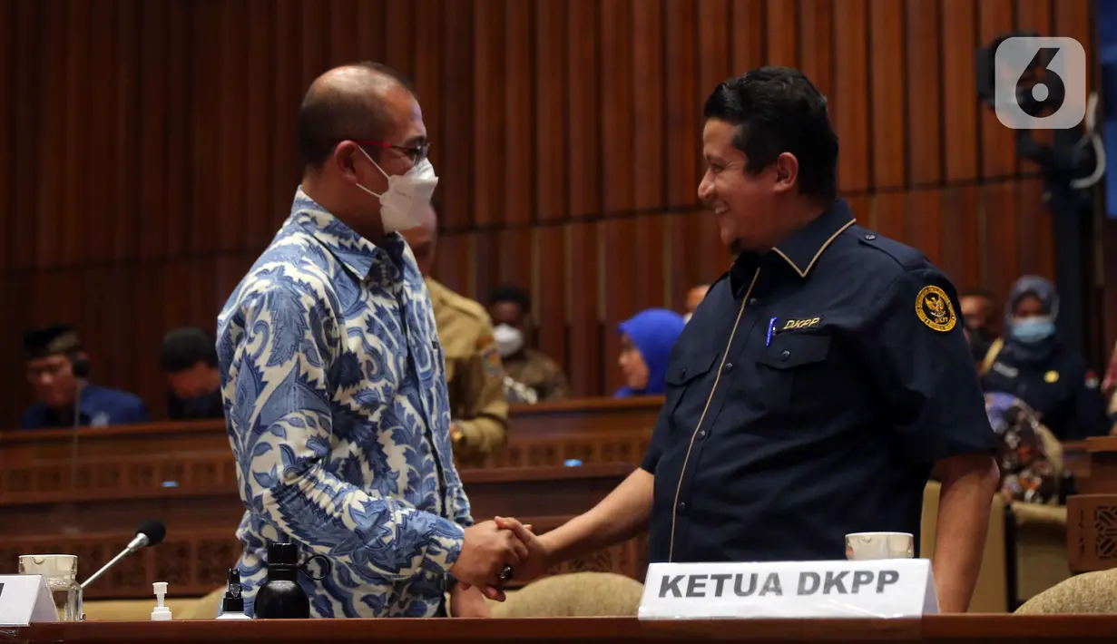 Ketua KPU Hasyim Asy’ari (kiri) bersalaman dengan Ketua DKPP Muhammad (kanan) saat rapat kerja bersama Komisi II DPR RI di Kompleks Parlemen, Senayan, Jakarta, Selasa (7/6/2022). Rapat membahas Peraturan KPU (PKPU) tentang Tahapan dan Jadwal Pemilu 2024. (Liputa6.com/Angga Yuniar)