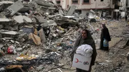 Para wanita Palestina saat meninggalkan Khan Yunis di Jalur Gaza Selatan pada 7 Maret 2024. Pada peringatan Hari Perempuan Internasional 2024, Kementerian Kesehatan Gaza mengumumkan kematian 9.000 perempuan Palestina di Jalur Gaza sejak 7 Oktober 2023. (Foto oleh AFP)