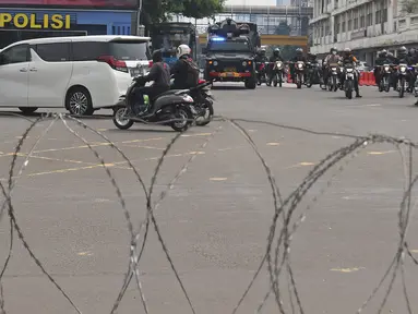 Petugas gabungan berpatroli di kawasan Harmoni, Jakarta, Sabtu (24/7/2021). Kepolisian menyiapkan kawat berduri di kawasan Harmoni untuk mengantisipasi adanya aksi demonstrasi dengan tuntutan menolak perpanjangan pemberlakuan pembatasan kegiatan masyarakat (PPKM). (Liputan6.com/Herman Zakharia)