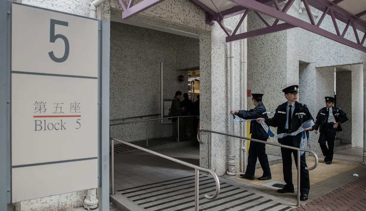 Polisi memasang garis polisi di pintu rumah Law Wan-tung setelah melakukan penyiksaan kepada TKI Erwiana Sulistyaningsih, Hong Kong, (21/01/2014). Polisi berhasil menahan Law Wan-tung saat mencoba kabur ke Thailand. (AFP PHOTO / Philippe Lopez)