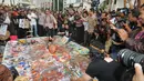 Di acara doa bersama yang digelar para seniman itu, Jokowi diminta membuka sepatu dan ikut menendang bola diatas poster yang penuh dengan lumuran cat, Bandung, Rabu (11/6/14). (Liputan6.com/Herman Zakharia)