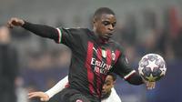 Bek AC Milan, Pierre Kalulu mengejar bola melewati pemain Tottenham, Arnaut Danjuma selama pertandingan leg pertama babak 16 besar Liga Champions di stadion San Siro di Milan, Italia, Rabu (15/2/2023). AC Milan menang tipis atas Tottenham dengan skor 1-0. (AP Photo/Luca Bruno)