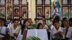 Paduan suara gereja Katolik mempersiapkan daun palem selama prosesi untuk menandai Minggu Palem di Gereja Kelahiran Bunda Maria, yang juga dikenal sebagai Gereja Katolik Kelahiran Santa Perawan Maria, di Surabaya pada 13 April 2025. (JUNI KRISWANTO/AFP)