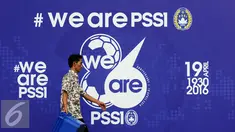 Seorang pria melintas di depan banner HUT PSSI ke-86 di Stadion GBK Jakarta, Selasa (19/4/2016). Setahun pasca dibekukan oleh Kemenpora, PSSI merayakan hari jadinya secara sederhana. (Liputan6.com/Helmi Fithriansyah)