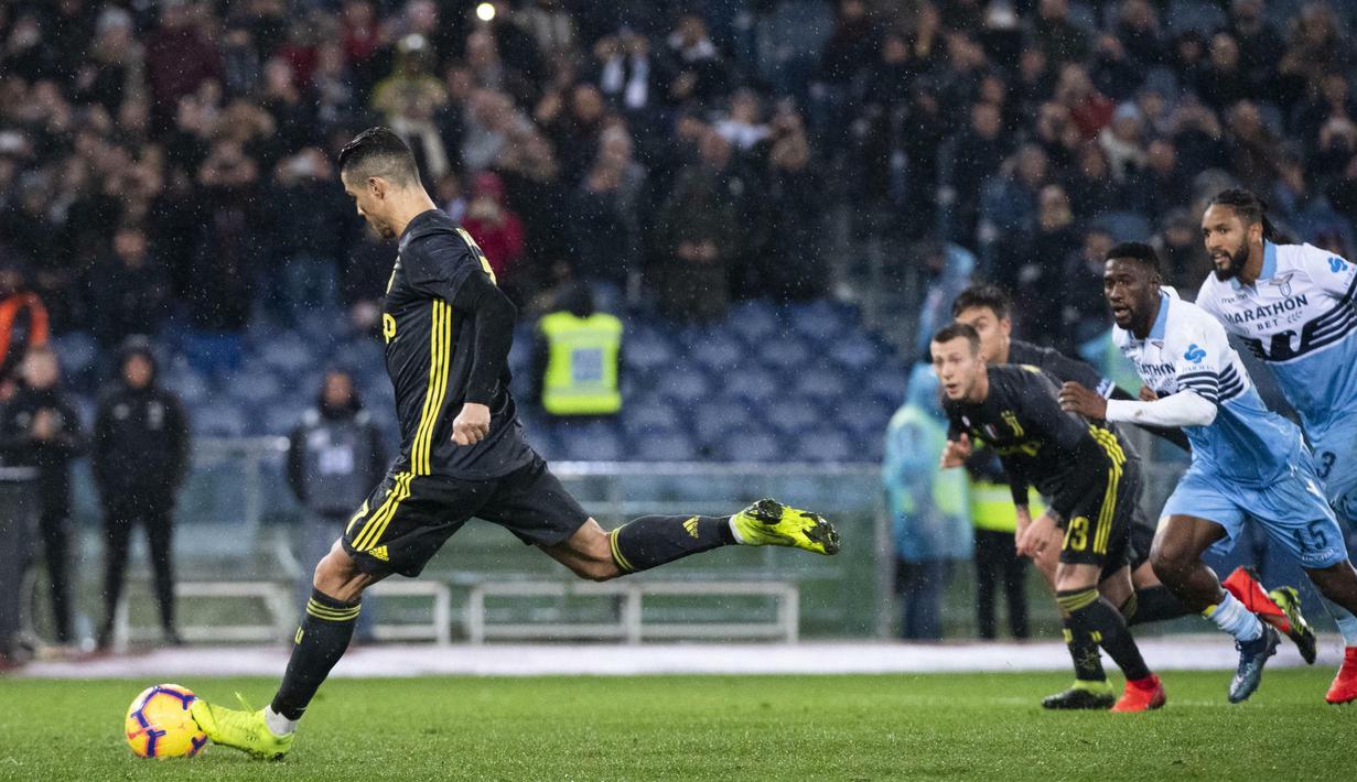 Striker Juventus, Cristiano Ronaldo, mencetak gol lewat tendangan penalti ke gawang Lazio pada laga Serie A di Stadion Olympic, Minggu (27/1). Juventus menang 2-1 atas Lazio. (AP/Claudio Peri)