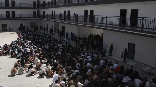 Warga China, Vietnam, dan Ethiopia, yang diyakini telah diperdagangkan dan dipaksa bekerja di pusat-pusat penipuan, duduk dengan wajah tertutup saat ditahan setelah dibebaskan dari Distrik Myawaddy, Myanmar, Rabu (26/2/2025).
