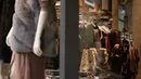 Seorang wanita melihat pakaian di dalam sebuah toko di Oxford Street di London, Senin (29/11/2021). Di Inggris, kewajiban mengenakan masker akan berlaku lagi di toko-toko dan transportasi umum mulai Selasa menyusul temuan Covid-19 varian Omicron. (AP Photo/Matt Dunham)