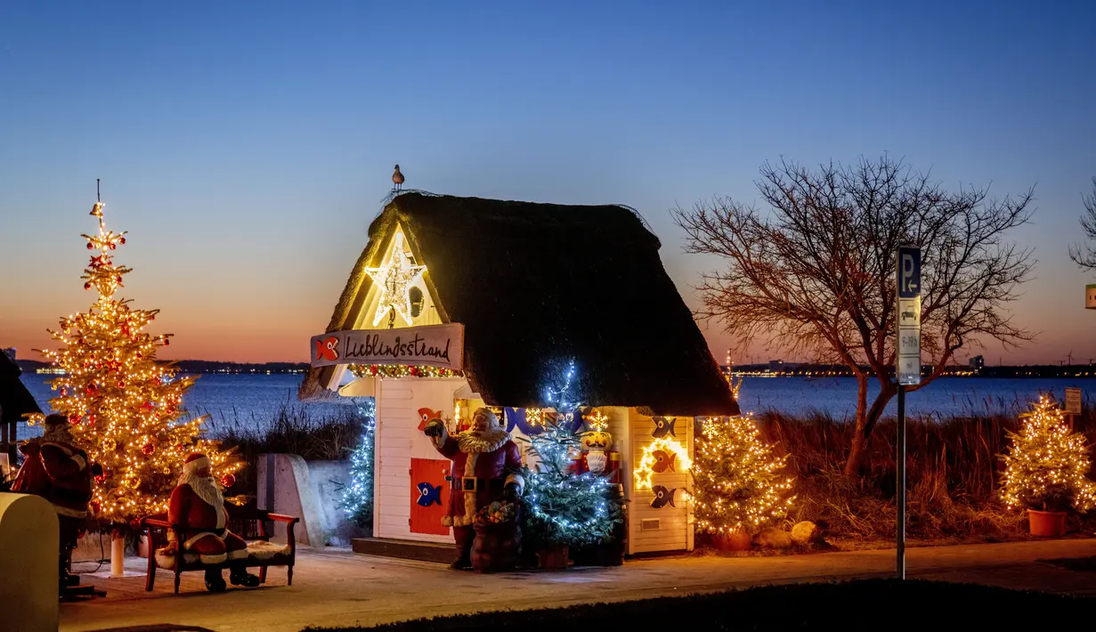 Pohon Natal dan Sinterklas menghiasi pintu masuk pantai di Haffkrug, Jerman utara, Senin (20/12/2021). (AP Photo/Michael Probst)