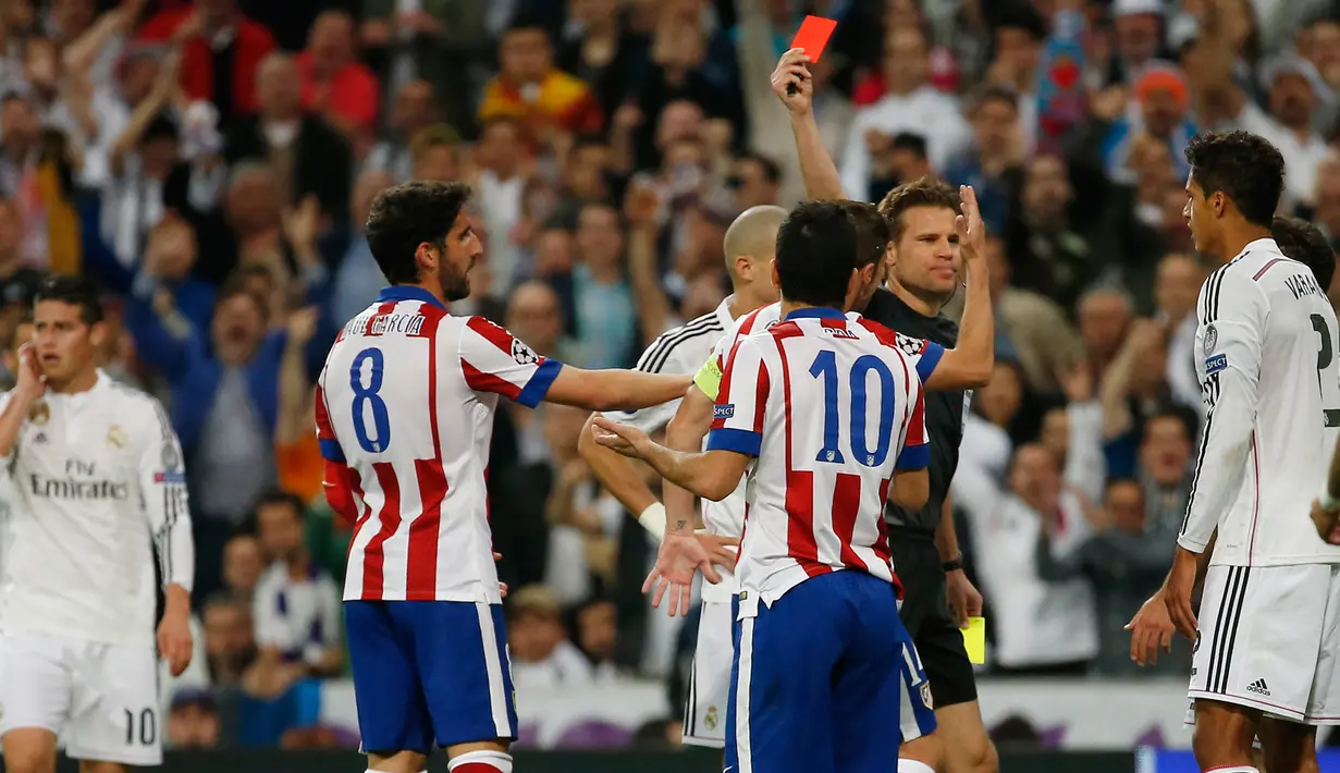 Wasit Felix Brych (kedua kanan) memberikan kartu merah kepada gelandang Atletico Madrid Arda Turan di leg kedua 8 besar Liga Champions di Santiago Bernabeu Stadium, Kamis (23/4/2015). Real Madrid menang 1-0 atas Atletico Madrid. (Reuters/Sergio Perez)