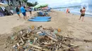 <p>Wisatawan asal Belanda mengumpulkan sampah sandal dan sepatu yang berserakan di Pantai Kuta. (merdeka.com/Arie Basuki)</p>