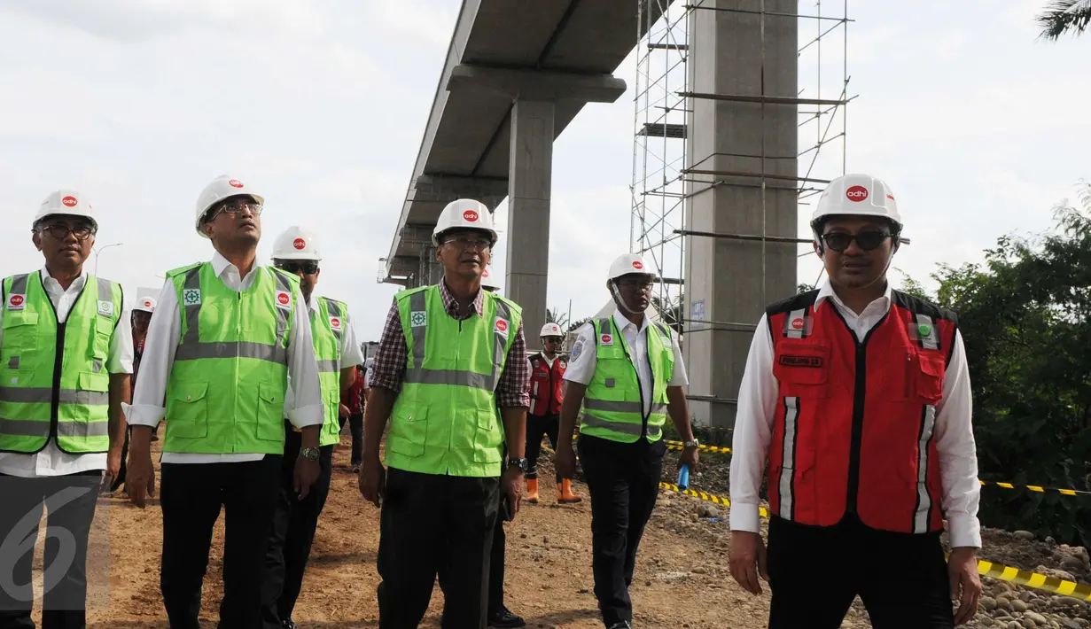 Menteri Perhubungan Budi Karya Sumadi memantau lokasi pembangunan kereta layang (Light Rail Transit/LRT), rute Cawang-Cibubur di tol Jagorawi Km 13, Jakarta, Minggu (8/1). LRT akan melewati 18 stasiun dengan panjang 42,1 km. (Liputan6.com/Helmi Afandi)