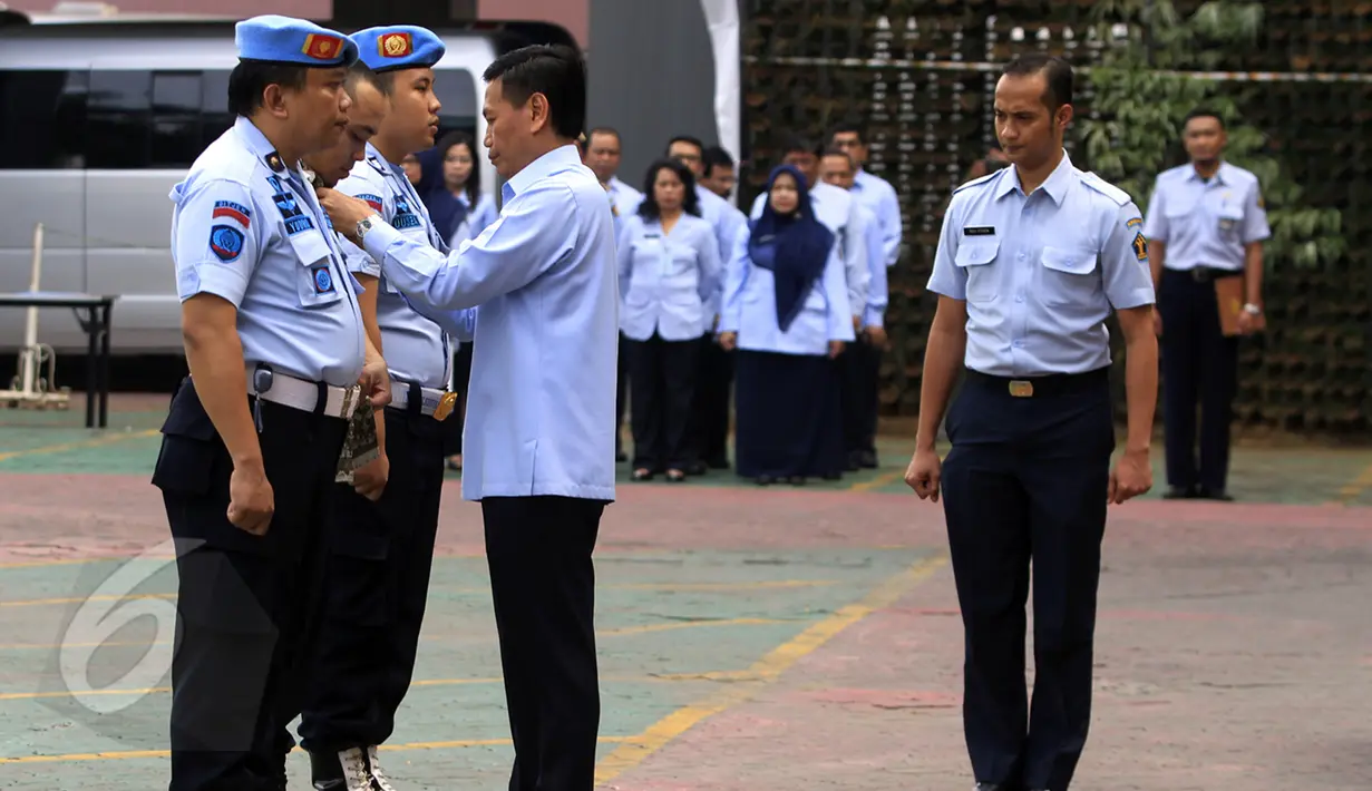 Sipir LP Kelas IIA Banceuy Bandung, yang menjadi tersangka peredaran narkoba di lapas, Dedi Romadi (tengah) mengenakan baju sipil usai melepaskan seragamnya pada upacara pemecatan di Lapangan Kemenkumham, Jakarta, Senin (1/6). (Liputan6.com/Johan Tallo)