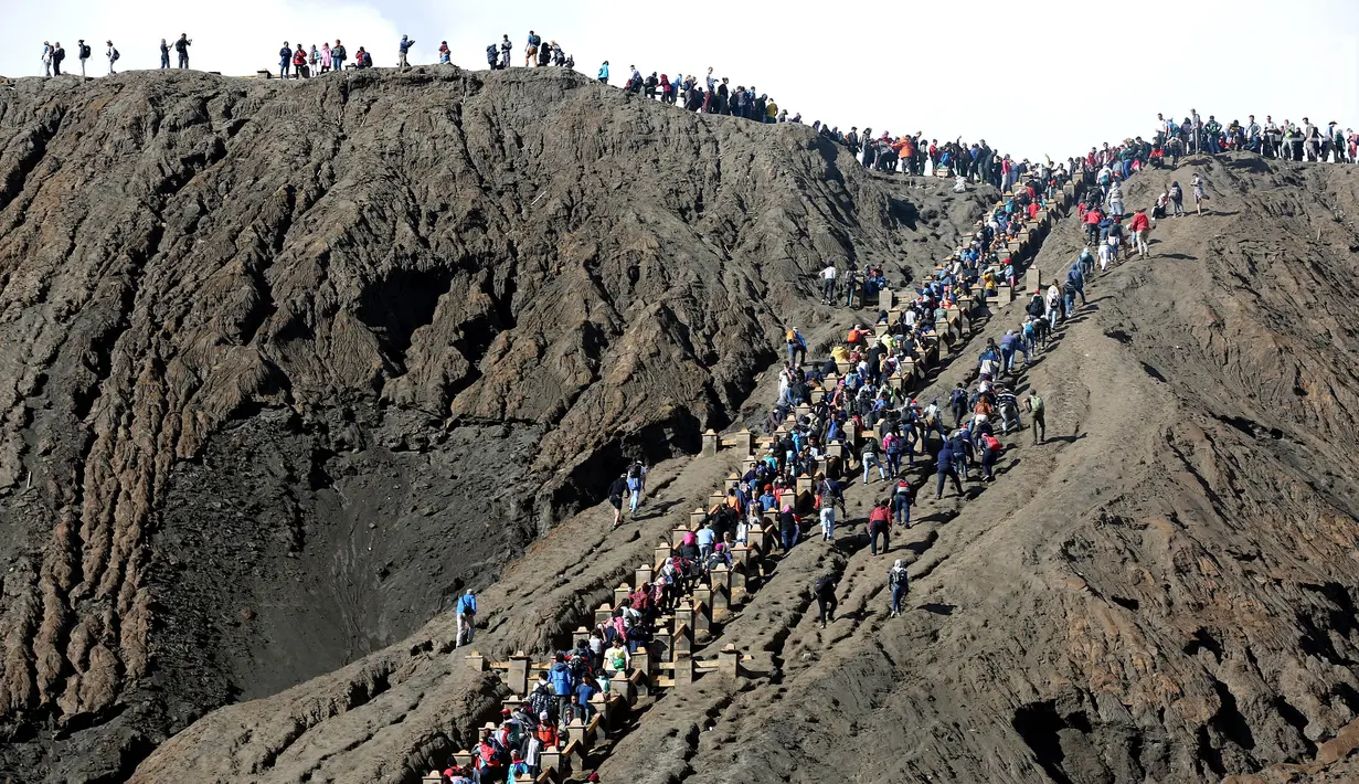 Wisatawan menaiki anak tangga menuju puncak  Gunung Bromo, Jawa Timur, (29/7). Ratusan wisatawan berbagai daerah setiap harinya memadati kawasan Bromo untuk berwisata melihat terbitnya matahari dan juga kawah Gunung Bromo. (Liputan6.com/Johan Tallo)