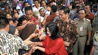 Presiden RI Joko Widodo beserta ibu Iriana disambut warga di sekitar Lapangan Bedeng, Pisangan Baru, Jakarta, Selasa (8/9/2015). Kedatangan Presiden Jokowi untuk memberikan sejumlah paket sembako dan buku kepada warga. (Liputan6.com/Helmi Fithriansyah)