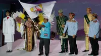 Perwakilan dari Papua mengibarkan bendera PON tanda siap mensukseskan PON Papua 2020 pada pentupan  PON XIX Jabar 2016 di Stadion Gelora Bandung Lautan Api, Kamis (29/9/2016). (Bola.com/Vitalis Yogi Trisna)